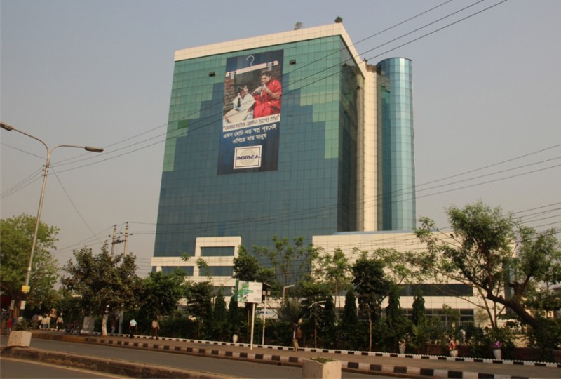 The offices of the Bangladesh Garment Manufacturers and Exporters Association, or BGMEA, tower above Dhaka. Four years ago, Bangladesh’s High Court has ruled that the building was built without proper approval and in an environmentally inappropriate place, and ordered it removed. It has not been. Credit: Bruce Wallace. Used with PRI's permission