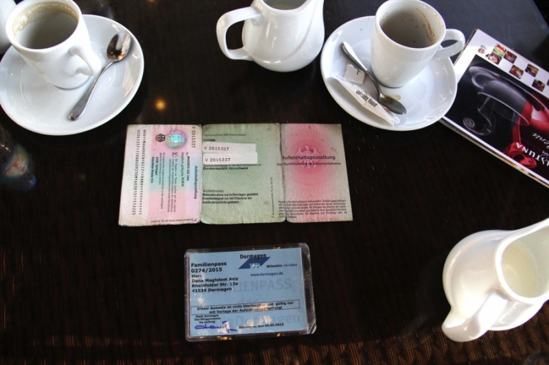 Dana Maghdeed Aziz’s German identification cards on the table in a café in Erbil. After months in Germany he still didn’t know if he would be granted asylum. Credit: Rebecca Collard