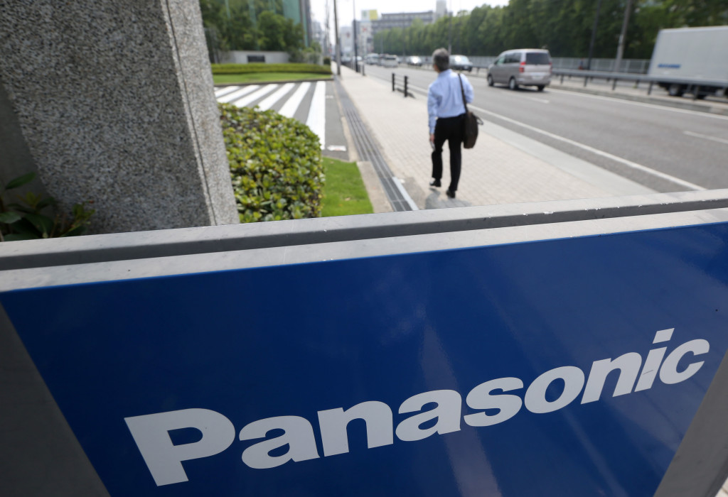 A man walks past Panasonic Corp. signage at the company's headquarters in Kadoma, Osaka Prefecture, Japan, on Wednesday, July 31, 2013. Panasonic, Japan's biggest consumer electronics maker, reported profit that exceeded analyst estimates after cutting wages, selling assets and a one-time gain from changes in pension accounting. Photographer: Tomohiro Ohsumi/Bloomberg